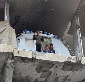 عائلة تحتمي من برد الشتاء القارس في خيمة نصبتها فوق منزلها المدمر قرب الخط الأصفر في خان يونس، جنوب قطاع غزة